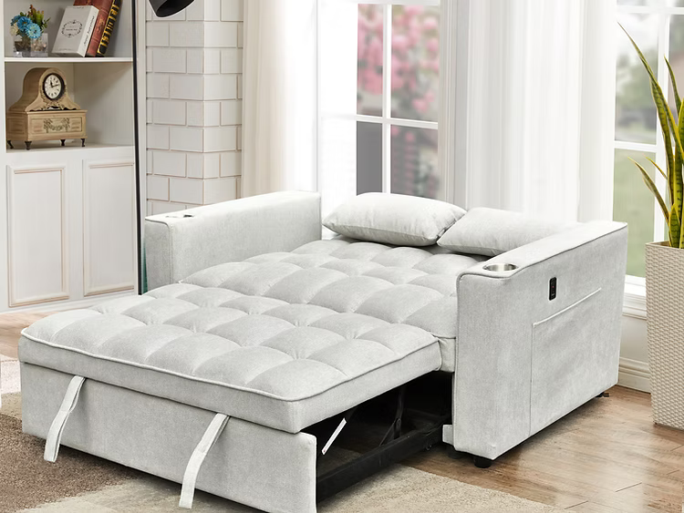 Canapé-lit gris moderne entièrement déplié avec assise matelassée et oreillers, dans un salon lumineux – Literie d’Amitié